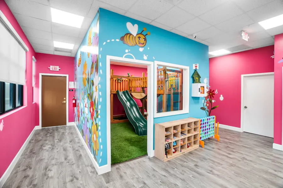 The indoor play village at Superhero Kids PPEC, with a painted bee above the door